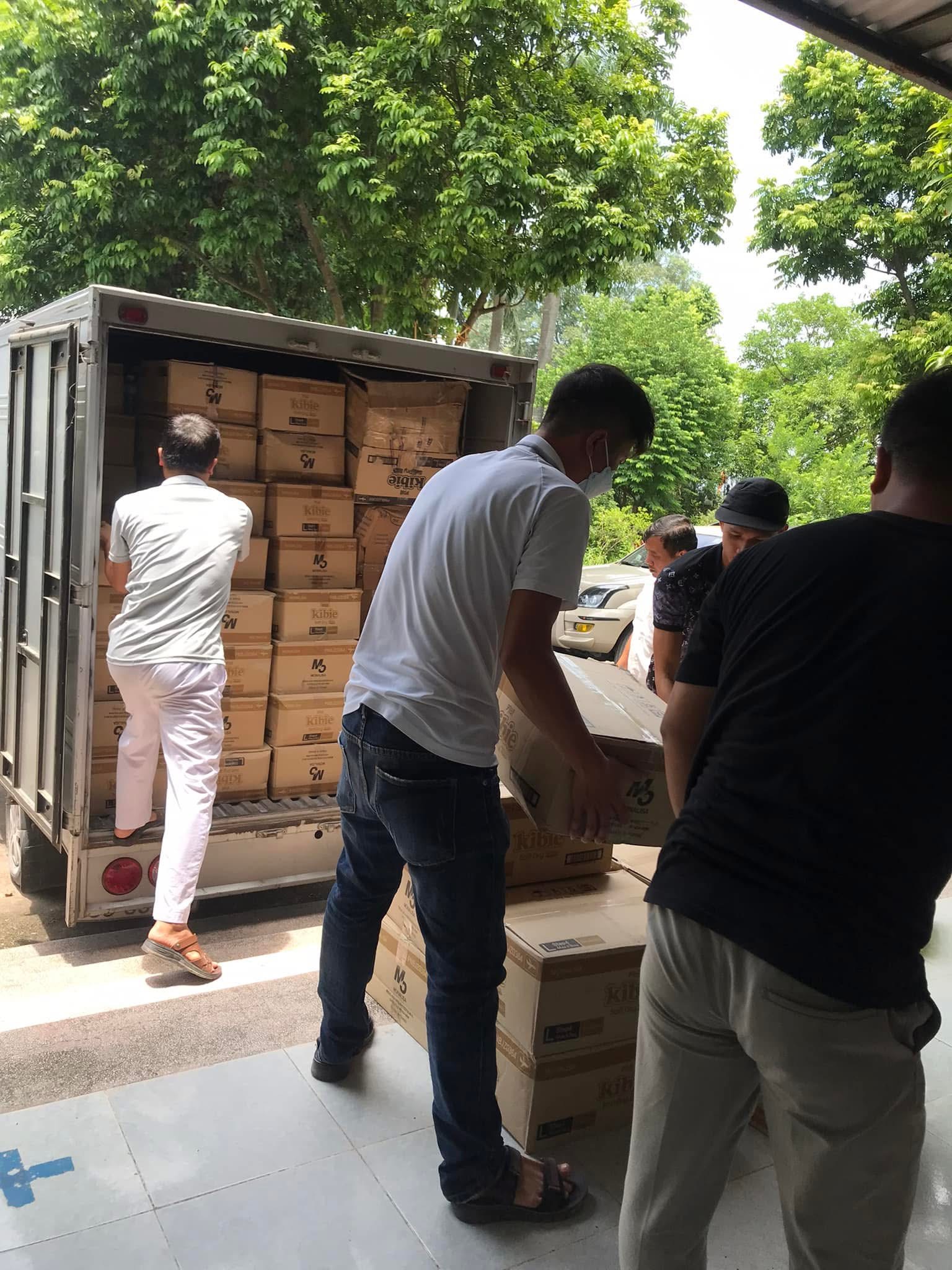 Tình nguyện viên vận chuyển các thùng bỉm từ xe tải